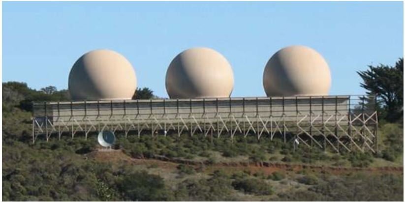 3 inflatable Radome bubbles on a hillside with wooden fence in front